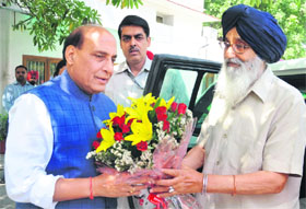 Chief Minister Parkash Singh Badal presents a bouquet to BJP national president Rajnath Singh at the latters residence in New Delhi on Wednesday.