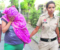 Accused Nisha Rana in police custody at Mohali on Thursday. A Tribune Photograph