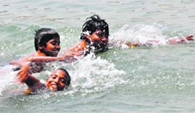 Beating the heat: With the rise in mercury, these children enjoy swimming in a canal in Karnal