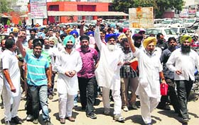 Akali workers hold a protest against the registration of a case against their two leaders in Kapurthala on Thursday