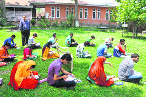 Students write their examination at Government Degree College, Bhaderwah, on Thursday as the college building developed cracks.