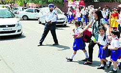 Parents help their wards cross a jam-packed road outside a school in Ludhiana