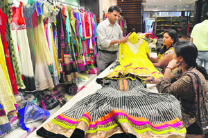 Women take a look at cotton suits at one of the stores on the Mall road in Ludhiana.