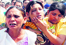 An inconsolable Sukhpreet Kaur, Sarabjit Singhs wife, and her daughters at the cremation ground in Bhikhiwind on Friday