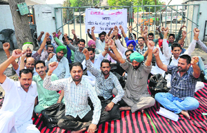 Members of the PRTC Contractual Workers Union (Azad) stage a dharna against the management outside the PRTC workshop in Bathinda on Saturday. The protesters are demanding regularisation of their services.