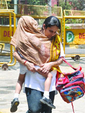 A mother tries to save her child from the scorching heat in New Delhi on Saturday.