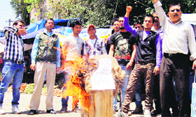 Members of the CPI ( ML) burn an effigy of the Chief Minister in support of their demand for action against Congress MLA Harish Dhami in Pithoragarh on Saturday.