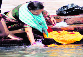 A woman washing clothes in the Ganga. Despite the Save Ganga campaigns, people washing clothes with detergents and soaps is a common sight on the ghats in Haridwar.