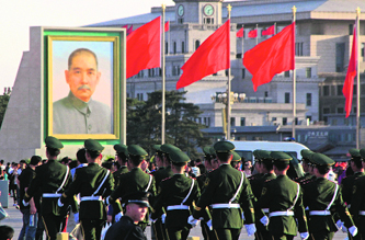 Paramilitary policemen walk past a portrait of Sun Yat-sen, the forerunner of Chinas revolution, ahead of May Day at Tiananmen Square in Beijing