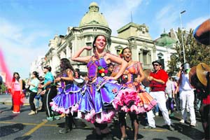 Participants in costume dance during a parade commemorating Earth Day in downtown Santiago