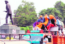Passengers atop a truck cover their face to ward off the heat wave in Amritsar on Sunday.