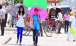 Girls use umbrellas to protect themselves from prickly sun-rays on Sunday