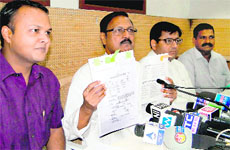BJP leader Satya Pal Jain shows documents in Chandigarh on Sunday. 