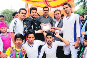 Members of the Jammu and Kashmir team pose for a photograph with the winners trophy in Mussoorie on Sunday