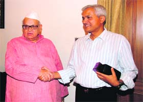 Governor Aziz Qureshi shakes hands with Ashok Pai, his former Principal Secretary in Dehradun