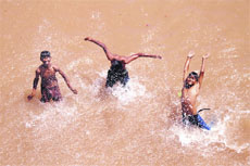 Children have a splash as they try to beat the heat in the river Tawi in Jammu on Sunday.