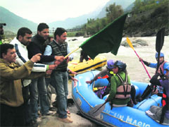 Kashmir Rafting Operators Association president Muhammd Ibrahim Raina flags off first batch of rafting enthusiasts at Yennar, Pahalgam, on Sunday. 
