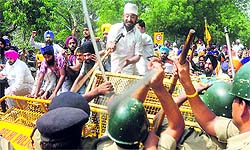 Angry Sikh protesters in Delhi try to break a police barricade as they march towards the Prime Ministers house to protest against the aquittal of Congress leader Sajjan Kumar in a 1984 riots case on Sunday
