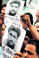 Workers hold posters of Sarabjit Singh
