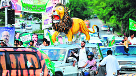 PML-N supporters march in a rally with a statue of a lion, the party election symbol, in Islamabad on Saturday.