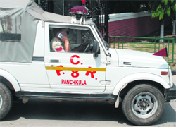 A policeman talks on his cellphone while driving during a rehearsal ahead of Rahul Gandhi's visit at the Indradhanush Auditorium in Sector 5, Panchkula, on Monday. 