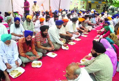 Sikh protesters eat langer (community food) at Jantar Mantar where Nirpreet Kaur, a victim of 1984 anti-Sikh riots, is sitting on an indefinite fast in New Delhi on Monday. 