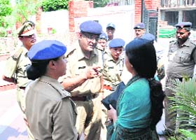 Policemen argue with a woman who staged a dharna outside the police headquarters, demanding action against a senior police official in Dehradun on Monday
