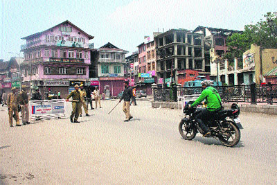Policemen stop a motorcyclist at a naka in Srinagar on Monday.