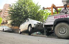 A recovery vehicle tows away a car that was wrongly parked on the Ferozepur Road service lane in Ludhiana.