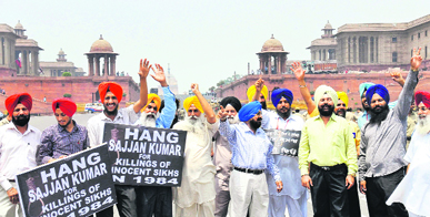 Protesters carrying placards raise anti-government slogans during a protest against the acquittal of Congress leader Sajjan Kumar outside Parliament House in New Delhi