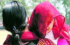 A woman tries to protect her young child from the risng heat with her dupatta in Dehradun on Tuesday