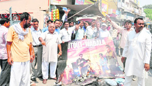 Members of the Valmiki community burn posters of Bollywood movie Shootout At Wadala in Karnal on Tuesday. 