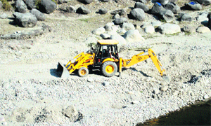 An earth remover used for mining in a river near Palampur. 