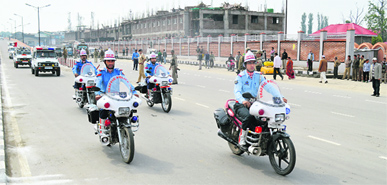 Traffic policemen on motorcycles along with other police vehicles escort Chief Minister Omar Abdullah on the second day of Durbar Move in Srinagar on Tuesday.