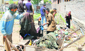 SMC workers pick garbage bags during a sanitation drive in Srinagar on Tuesday.