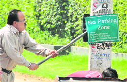 An MC official removes a no parking board from outside a house at BRS Nagar in Ludhiana on Tuesday. Tribune photo: Himanshu Mahajan