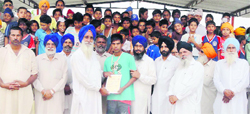 Pugilist Harjit Singh being felicitated by villagers at Chakar village. A TRIBUNE PHOTOgraph