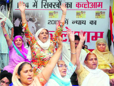 Women raise slogans against the aquittal of Sajjan Kumar at Jantar Mantar in New Delhi on Tuesday.
