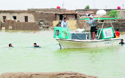 Rescue teams help people get across a flooded area in Sheikh Saad district, south Baghdad, on Monday. Heavy rains flooded villages in southeastern Iraq forcing people to evacuate their homes.  Reuters