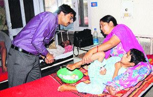 Deputy Commissioner Ashish Singhmar talks to an indoor patient at the Regional Hospital in Hamirpur on Wednesday.