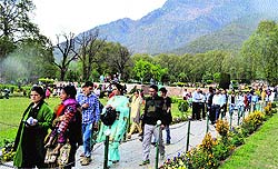 Locals and tourists enjoy the scenic beauty of Nishat Garden in Srinagar on Wednesday