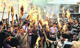 Employees of the Public Health Engineering Department carry torches during a protest in Srinagar on Wednesday.
