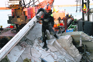 A rescue team searches through the debris of the collapsed control tower of Genoas port on Wednesday