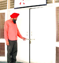 An employee of the ART (anti-retroviral treatment) Centre at Guru Nanak Dev Hospital shows the lock of a door, broken by robbers, in Amritsar on Thursday. 