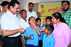 Civil surgeon Ajay Sahni administers the first dose of Albendazole to a student at Desraj Memorial Government Senior Secondary School in Bathinda on Friday