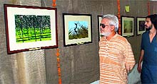A visitor looks at a photograph during an exhibition at the Teachers' Home in Bathinda on Friday