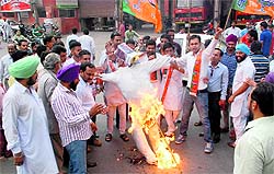 BJP activists burn an effigy of the Central Government during a protest against corruption in Bathinda on Friday