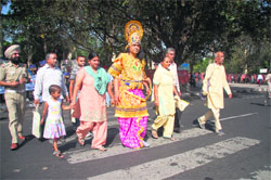 A man dressed up as Lord Rama helps patients and their attendants cross a road outside the PGIMER on Friday. 