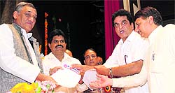 State government employees present a charter of demands to Chief Minister Vijay Bahuguna at a convention in Town Hall in Dehradun on Friday