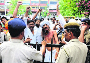 Cow protection activist Gopal Das and his supporters shout slogans against the Haryana Government in protest against the police refusal to allow entry into the mini-secretariat in Karnal on Friday. He demands restoration of open grazing land for cows in all districts of the state. 